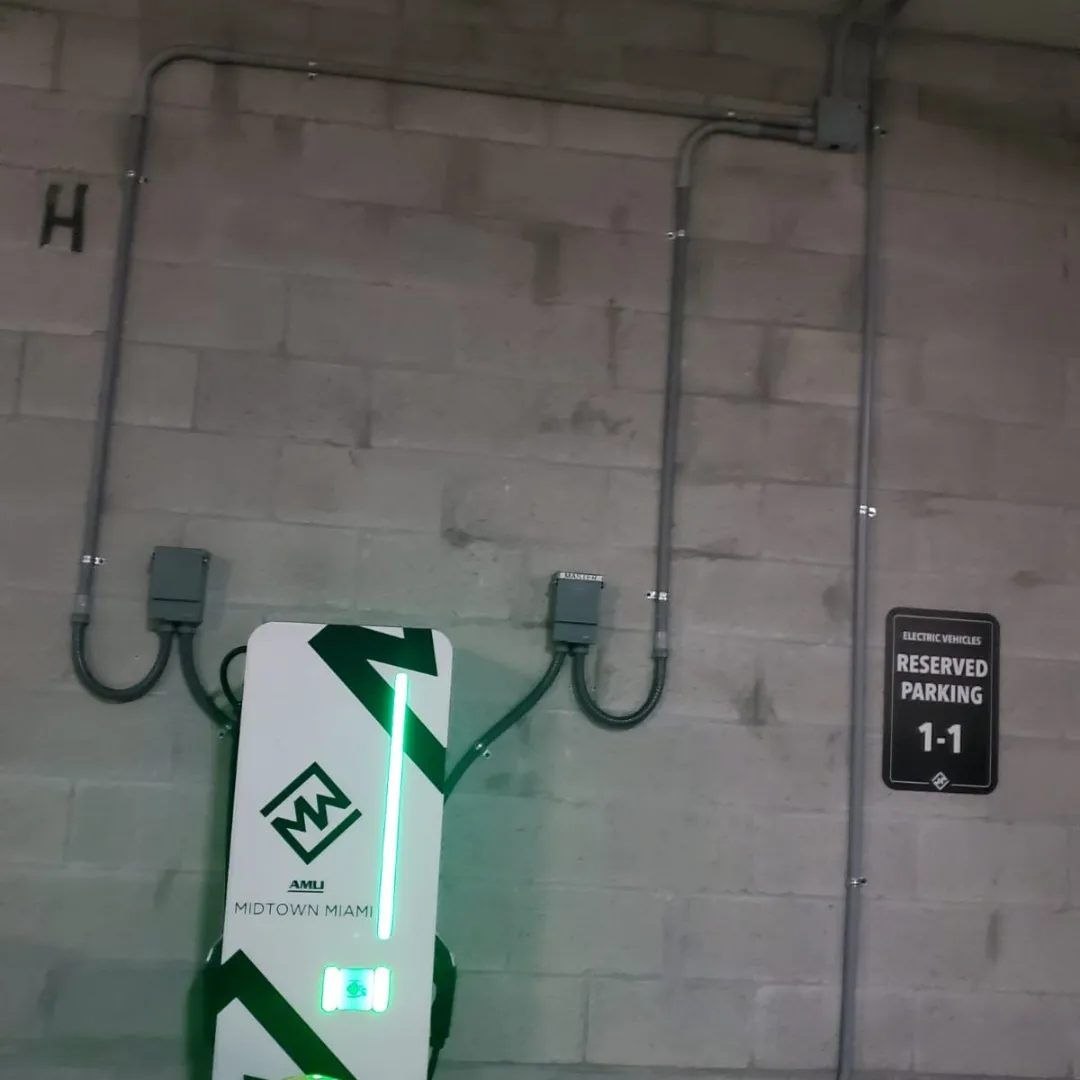 Wall mounted electric vehicle charger with conduit runs in a parking garage