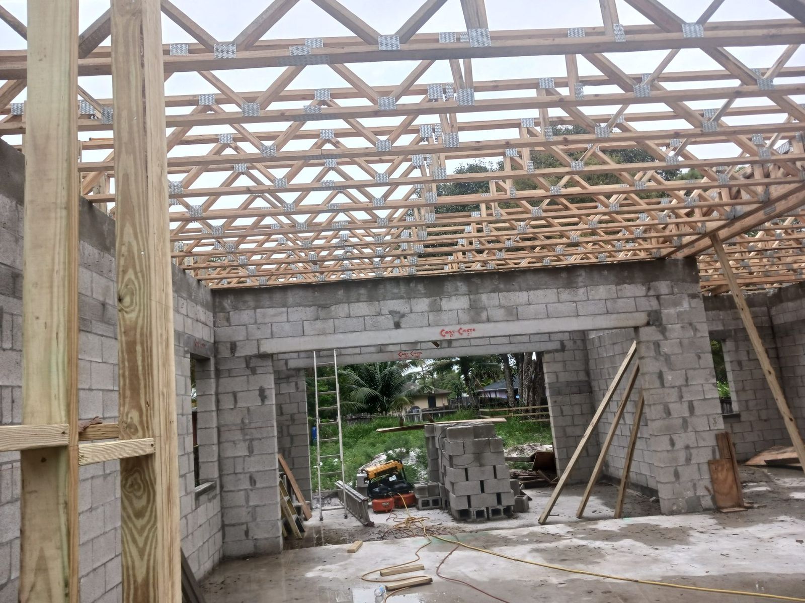 Residential addition under construction with block walls and open trusses