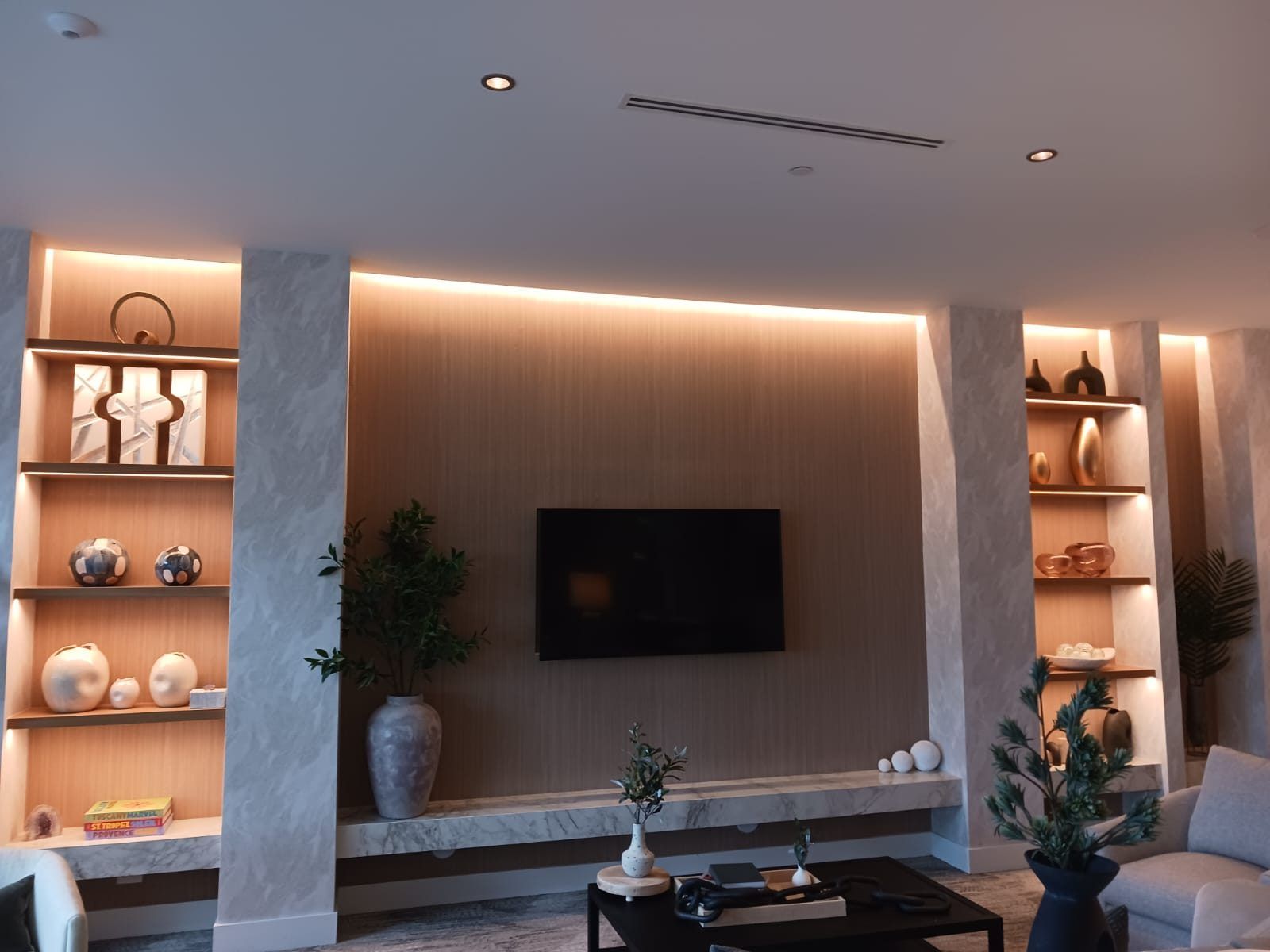 Interior feature wall lit with recessed downlights and concealed cove lighting